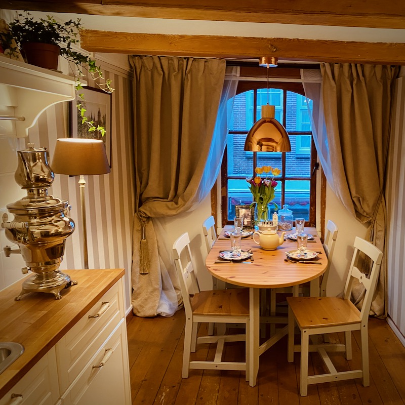 A picture of the interior of the Smallest House in Amsterdam. At the front a kitchen with a samovar on top.